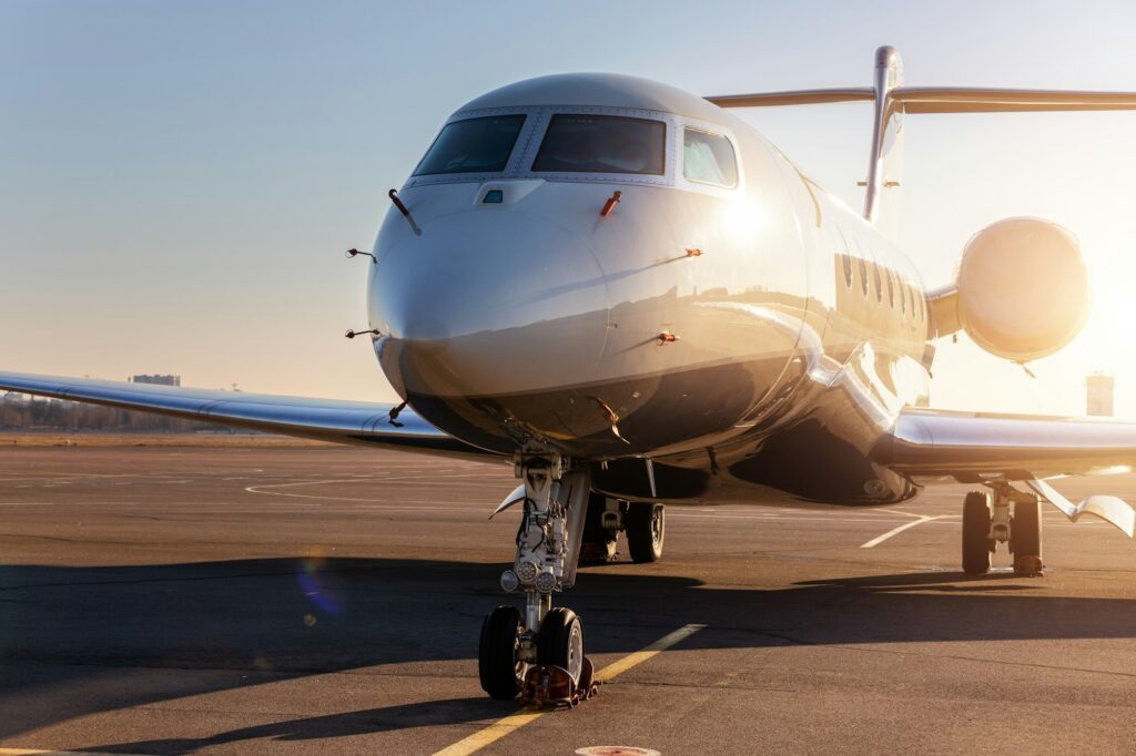 Scenic front view modern luxury expensive private jet plane parked airport taxiway hangar warm